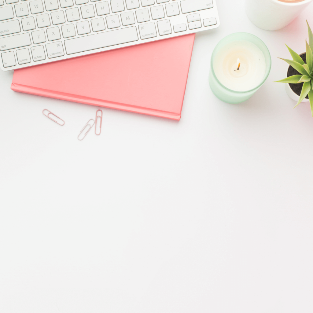 white desk with pink book and candle