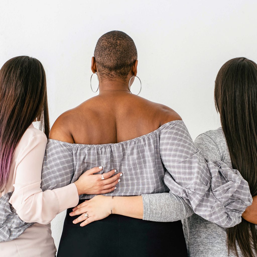 3 diverse girls embracing from behind tall