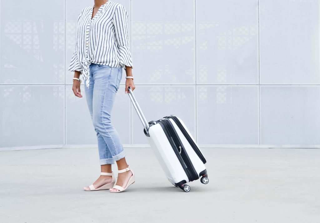 girl in denim with rolling suitcase